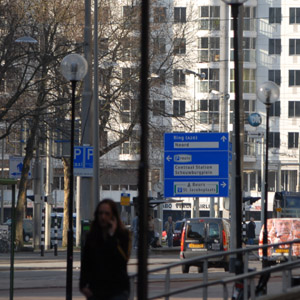 Illustratie: stadsgezicht met mobiele beller, verkeersborden en reclames